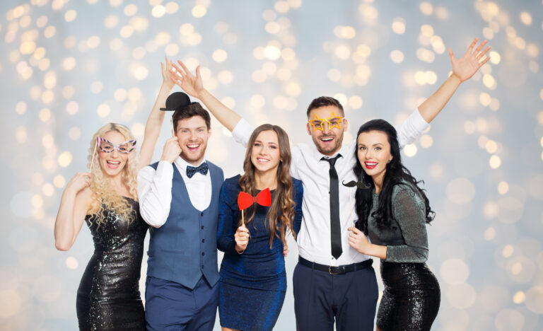 happy friends with party props posing over lights